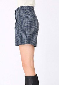 Shorts à motif bleu et blanc avec une coupe ajustée, en tissu texturé, taille haute et coupe droite. Poches non fonctionnelles à l'avant.