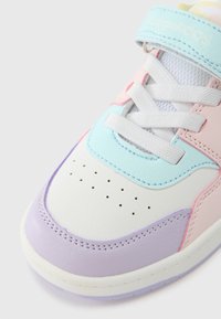 Πολύχρωμο αθλητικό παπούτσι με λευκά, ροζ, μπλε και λεβαντίνια πάνελ. Ομαλά και υφή υλικά, με εμφανείς τρύπες και κορδόνια.