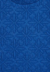 Blått texturerat tyg med ett geometriskt mönster som har bladliknande motiv. Slät yta med en svag lyster, rund halsringning.