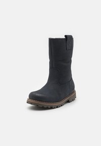 Bottes en cuir bleu marine avec une tige droite, surface texturée, semelle en caoutchouc marron et une petite languette à l'arrière pour un enfilage facile.