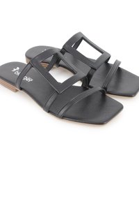 Sandalias planas negras con diseño de punta cuadrada, que cuentan con dos tiras anchas y un acento de corte rectangular. Fabricadas en cuero sintético con un acabado texturizado.