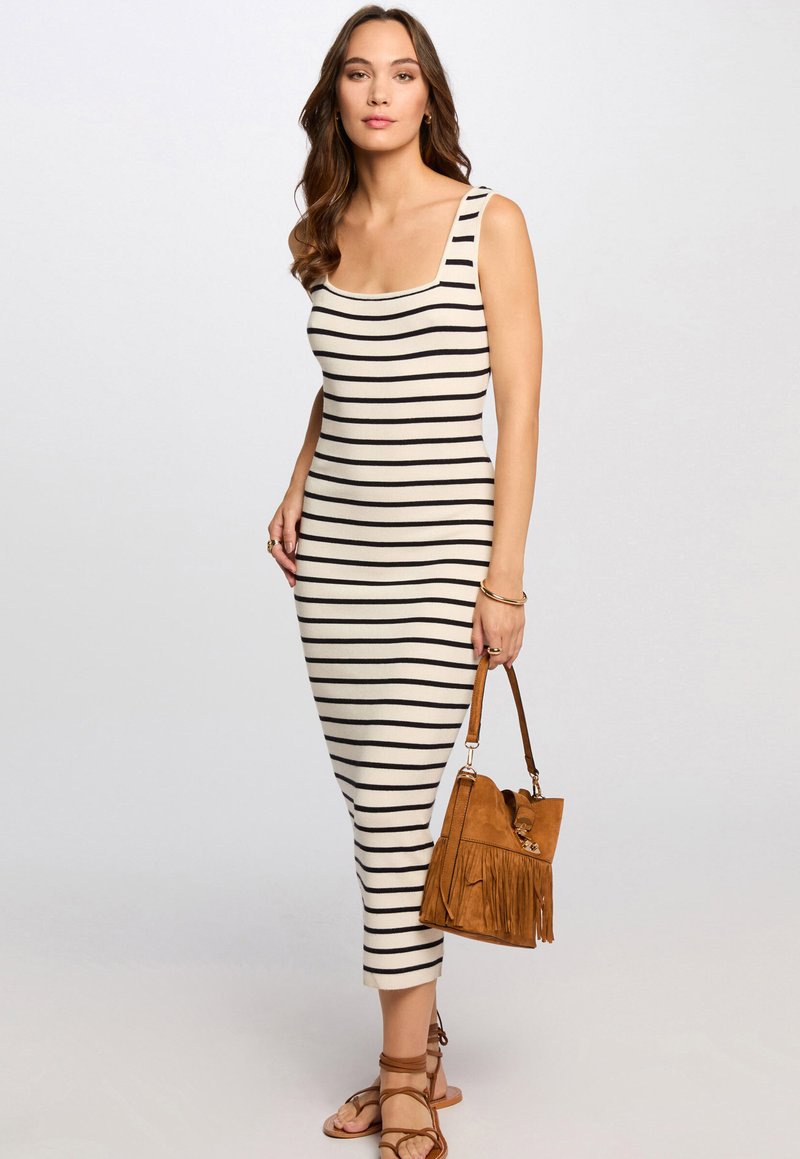 Robe midi rayée en crème et noir, dotée d'un col carré et d'une coupe ajustée. Associée à un sac à main en suède marron à franges et des sandales à lanières.