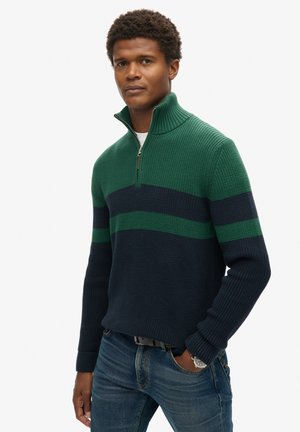 Suéter de punto en azul oscuro y verde con cuello de cremallera de un cuarto y tejido texturizado. Presenta rayas horizontales en verde y marino.