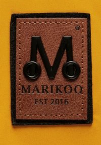 Brunt lädermärke med en upphöjd svart "M"-logotyp med cirkulära detaljer och präglad text "MARIKOO EST 2016" mot en gul bakgrund.