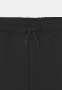 Zwarte sweatpants met een elastische tailleband en een trekkoord, een gladde textuur en dubbelgestikte details bij de naden.