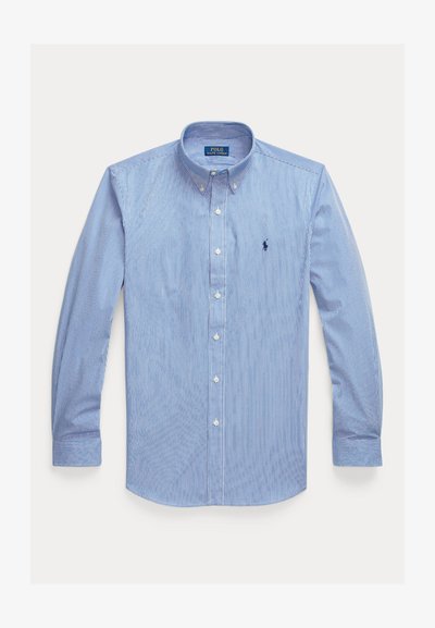 Kék-fehér, függőleges csíkos, hosszú ujjú, gombos ing gombos gallérral és kis hímzett logóval a mellkasán.