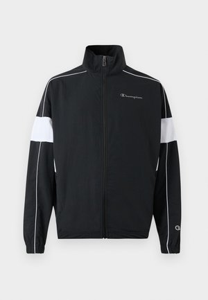 Giacca sportiva nera con pannelli laterali bianchi, chiusura con zip, colletto alto, polsini elastici e logo Champion sul petto. Materiale leggero.