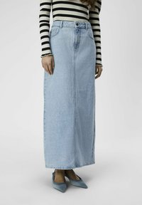 Light blue denim maxi skirt with a straight design and front seam, paired with a black and white striped long-sleeve top and blue pointed shoes.