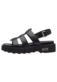 Sandali neri in pelle con tre fasce larghe, fibbia regolabile alla caviglia, suola spessa e testurizzata, e logo in metallo sul lato.
