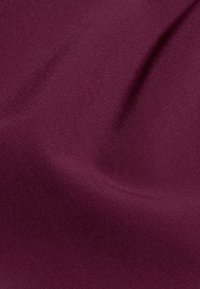 Un tissu violet foncé lisse avec des plis doux et une légère texture en vue rapprochée.