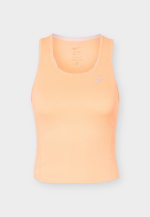 Débardeur de sport sans manches couleur pêche pour femme avec encolure ronde et petit logo Nike gris clair sur la poitrine.