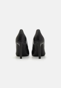Melni ādas augstpapēžu apavi ar norādītu pirkstu, gludu augšdaļu un augstu, šauru stiletto papēdi. Gluda tekstūra, minimālas šuvju detaļas.