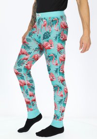 Leggings featuring a turquoise background with a vibrant pink flamingo and green leaf pattern. Made of stretchy fabric with a fitted design.
