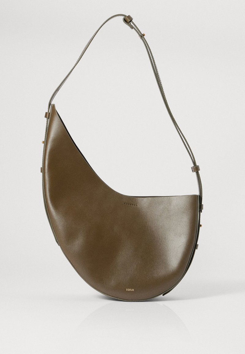 Καφέ δερμάτινη τσάντα ώμου με καμπύλη, ημισφαιρική σχήμα, λεπτό λουρί και διακριτές χρυσές λεπτομέρειες. Λείο υλικό.