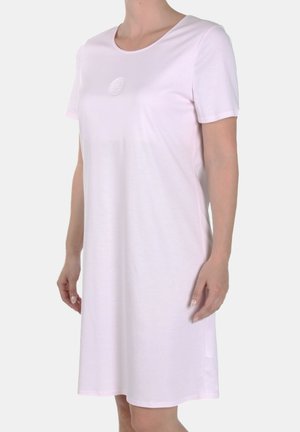 Vrouw met een effen lichtroze korte mouw jurk met een ronde hals en een klein geborduurd logo op de borst.