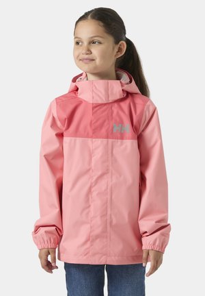 Meisje dat een waterdichte jas met twee tinten roze en een capuchon draagt, staand en lichtjes opzij kijkend tegen een effen achtergrond.