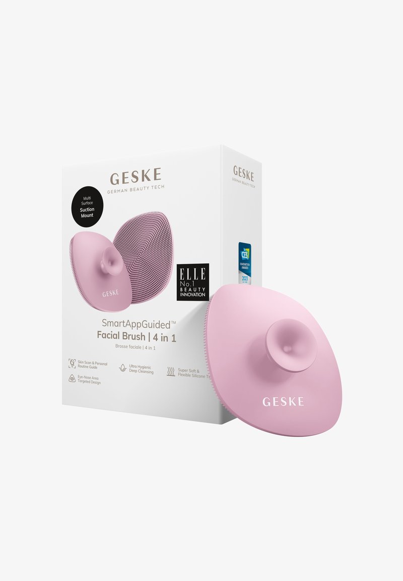 Roze siliconen gezichtborstel met zuignap, ronde vorm, gestructureerd oppervlak en bijbehorende verpakking met merk- en productinformatie.