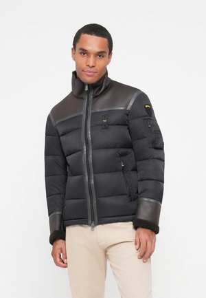 Giacca nera imbottita con accenti in pelle. Presenta un colletto alto, una cerniera frontale e due tasche laterali, polsini texturizzati con foderatura in pelliccia.