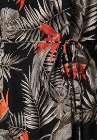 Černá tkanina s tropickým vzorem listů v šedé a oranžové, s tkaničkou v pase a jemným lesklým vzhledem.