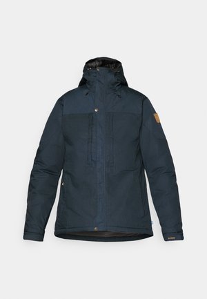 Dunkelblaue isolierte Jacke mit Kapuze, Fronttaschen und Reißverschluss. Sie verfügt über einen strukturierten Stoff und ein beigefarbenes Logo-Patch am Ärmel.