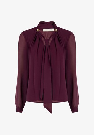 Blusa color bordeaux in chiffon leggero con maniche lunghe, dettaglio con fiocco al collo e accenti dorati sul colletto, dal design fluido.