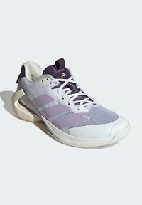 Baskets de sport violettes et blanches avec une tige en mesh, trois bandes de signature, une semelle texturée et un talon renforcé pour le soutien.