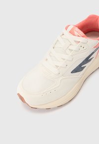 Hvit sneaker med overdel i mesh og semsket skinn. Har en rosa innerfôr, grå aksentlogo, og en beige midtsåle med en teksturert brun såle.