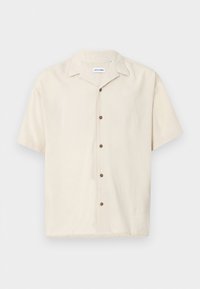 Short-sleeved beige shirt made of a smooth fabric. Features a pointed collar and brown buttons along the front.
