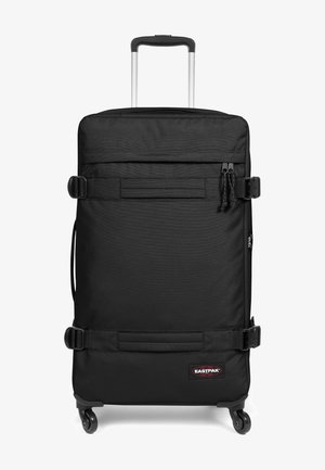 Maleta negra de ruedas hecha de un tejido duradero con un acabado texturizado, que cuenta con un mango telescópico, hebillas seguras y un parche con el logo.