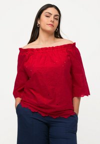 Rode off-the-shoulder blouse met 3/4 mouwen, bloemenogen patroon, gerimpelde halslijn en golvende zoom. Lichtgewicht stof, casual pasvorm.
