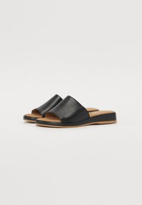 Black leather slide sandals with a wide upper band and a slight wedge heel. Smooth texture with a brown sole and simple design.