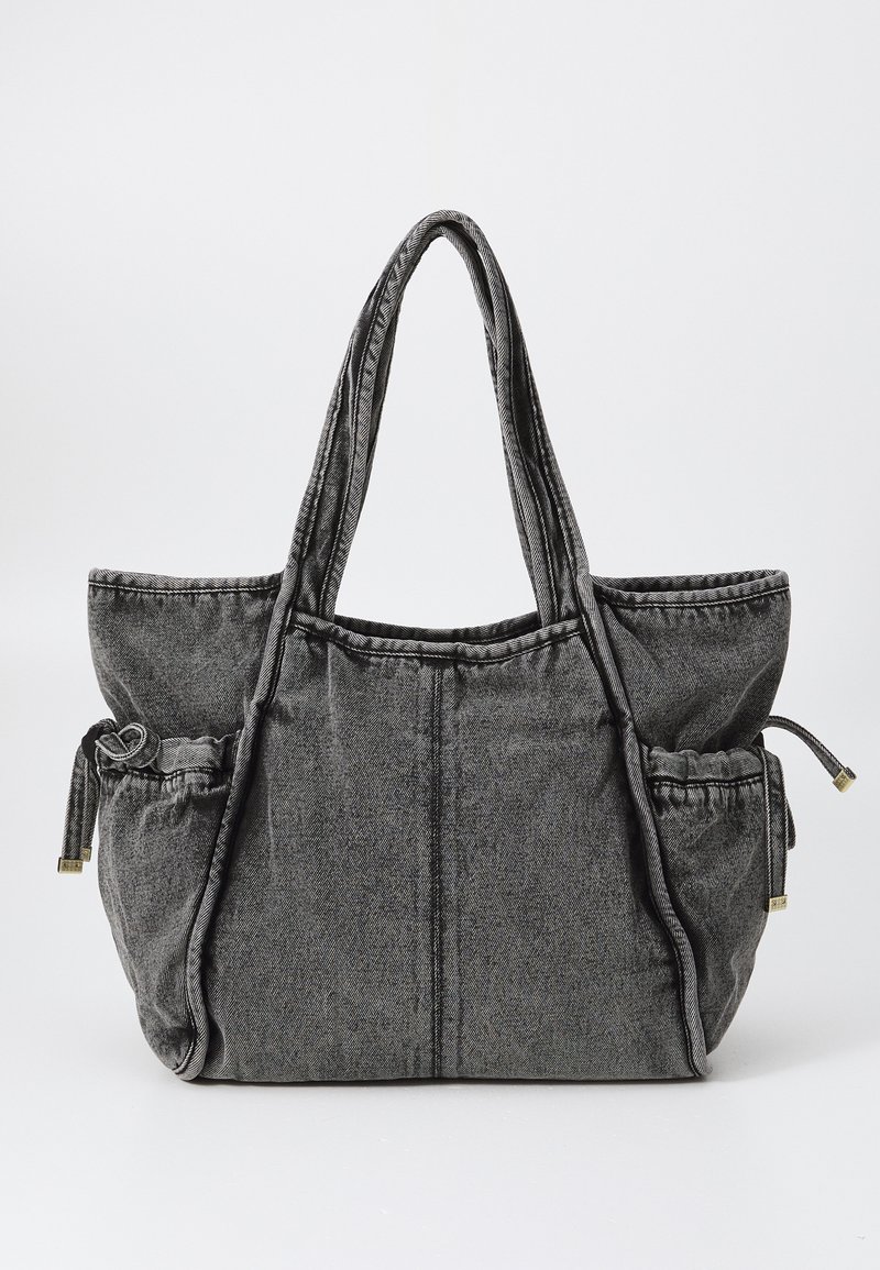 Graue Stofftasche mit doppelten Schulterträgern, zwei Seitenfächern mit Kordelzugverschlüssen und einem strukturierten Design.