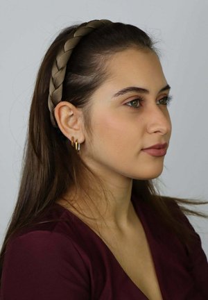 Brązowa pleciona opaska na głowę z gładką fakturą oraz złote kolczyki koła. Modelka ma długie brązowe włosy i nosi bordową bluzkę.