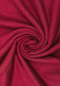 Tessuto rosso con una texture liscia e morbida, arrotolato a spirale. Il materiale appare leggero con una sottile lucentezza e un leggero effetto melangiato.