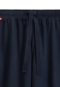 Granatowe dresy z elastycznym paskiem w pasie i dopasowanym sznurkiem, wykonane z miękkiego, gładkiego materiału.