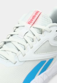 Sneaker Reebok bianca con tessuto in rete, lacci bianchi, una striscia blu sul lato e un'etichetta Reebok rossa sulla linguetta.