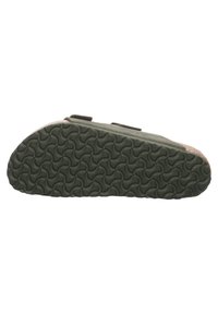 Green slip-on shoe with a textured rubber sole featuring a wave pattern, and a fabric upper with contrasting colored accents. Two adjustable straps.