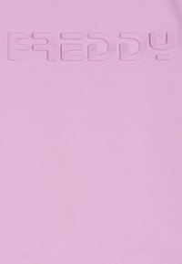 Sudadera de color rosa claro con un logo en relieve "FREDDY" en un tono ligeramente más oscuro. Textura suave con un diseño casual.