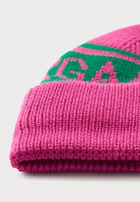 Bright pink knit beanie with folded cuff, featuring green and pink pattern detail near the top edge against a plain background.