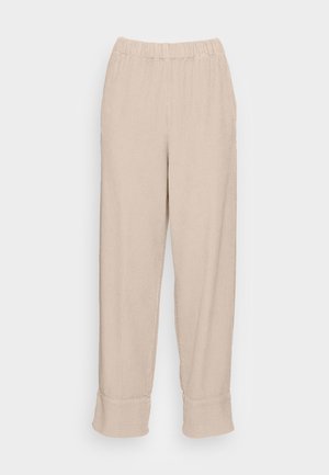 Beige geribbelde broek met een elastische tailleband, rechte benen en omgeslagen zoom. Zachte textuur met een subtiel, consistent patroon door het geheel.