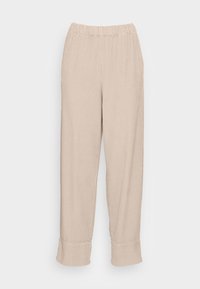 Beige geribde broek met elastische tailleband en brede boorden, plat getoond op een lichte achtergrond.