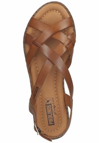 Brown leather sandal with crisscross straps, padded footbed, and a textured rubber sole. Features logo on insole and side zipper.