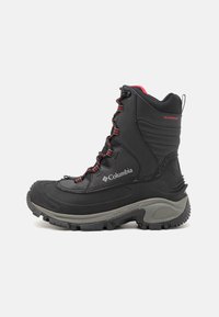 Bottes d'hiver noires et imperméables avec une semelle grise. Elles présentent des lacets rouges, un excellent soutien de la cheville, un motif de semelle prononcé et le logo Columbia sur le côté.