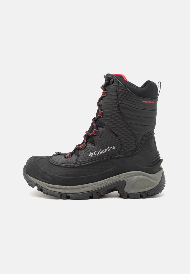 Bottes d'hiver noires et imperméables avec une semelle grise. Elles présentent des lacets rouges, un excellent soutien de la cheville, un motif de semelle prononcé et le logo Columbia sur le côté.