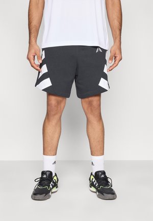 Μαύρο αθλητικό σορτς με λευκές διαγώνιες ρίγες, συνδυασμένο με μαύρα και πράσινα αθλητικά παπούτσια και λευκές κάλτσες. Ύφασμα λείας υφής, άνετη εφαρμογή.