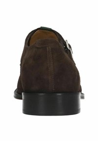 Chaussure en suede marron avec un petit talon, dotée d'une fermeture éclair sur le côté et d'une semelle en cuir lisse. Présente des détails de couture minimaux.