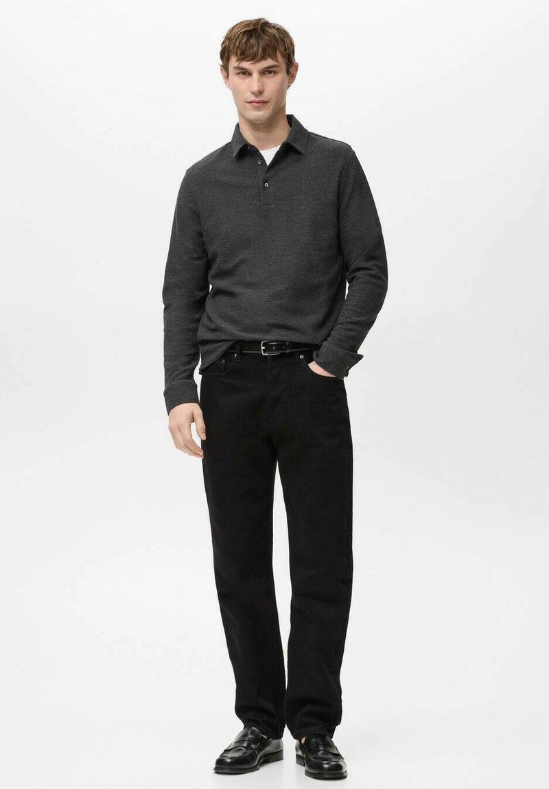 Schwarzes langärmeliges Poloshirt mit Kragen, kombiniert mit schwarzer Hose und schwarzen Schuhen. Der Stoff hat eine glatte Textur und ein figurbetontes Design.