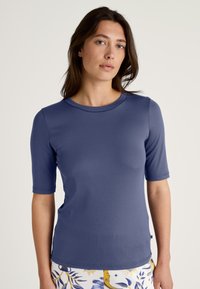 Marineblauwe t-shirt met korte mouwen in een gladde, rekbare stof, met een ronde halslijn en subtiele stikseldetails op de mouwen en zoom.