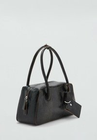 Bolso rectangular de piel negra con dos asas largas, cremallera visible en un lado y etiqueta de cuero adjunta sobre un fondo liso.