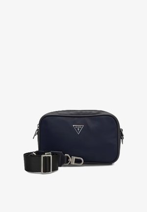 Kleine rechthoekige zwarte en navy crossbodytas met een afneembare brede zwarte band en metalen Guess-logo aan de voorkant.